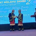 Ketua Umum LAM Provinsi Jambi Hasan Basri Agus menyerahkan buku daras adat Melayu Jambi kepada Gubernur Jambi Al Haris. Foto: Riky Serampas/Pariwarajambi