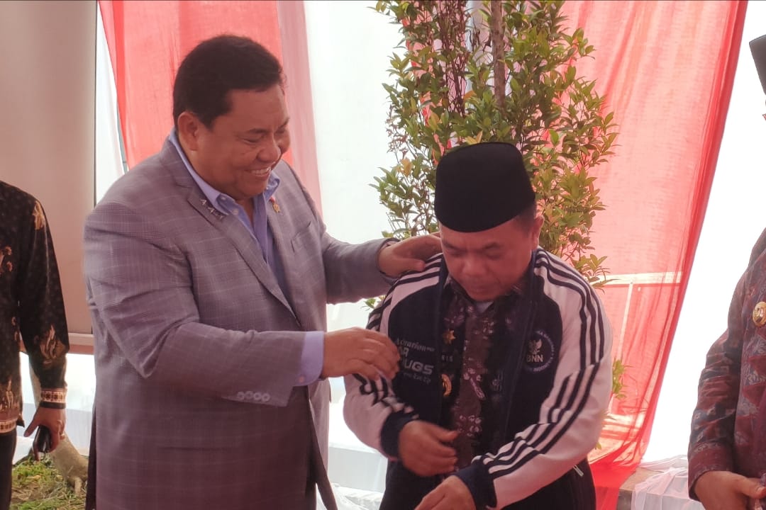 Kepala BNN RI Komjen Pol Petrus Reinhard Golose memasangkan jaket BNN kepada Gubernur Jambi Al Haris. Foto: Riky Serampas/Pariwarajambi
