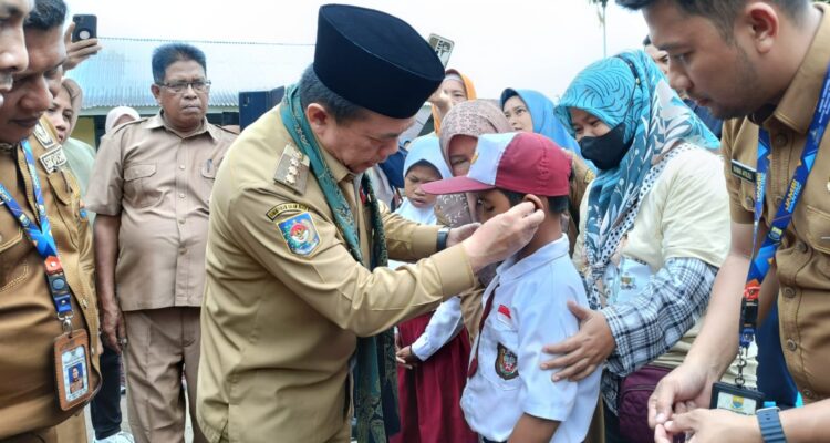Gubernur Jambi Al Haris menyerahkan bantuan dengar kepada Alfikhoiri salah seorang siswa SLB Kabupaten Batanghari penerima bantuan Dumisake Pendidikan 2023. Foto: Riky Serampas/Pariwarajambi