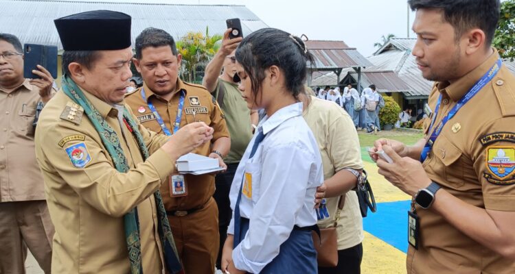 Gubernur Jambi Al Haris menyerahkan alat bantu dengar kepada siswa SLB. Bantuan ini merupakan program Dumisake pendidikan Gubernur Jambi. Foto: Riky Serampas/Pariwarajambi